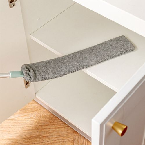 Gray microfiber duster being used on a white cabinet.