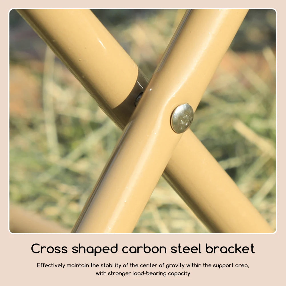 Close-up of a cross-shaped carbon steel bracket on a bicycle frame with a blurred natural background.