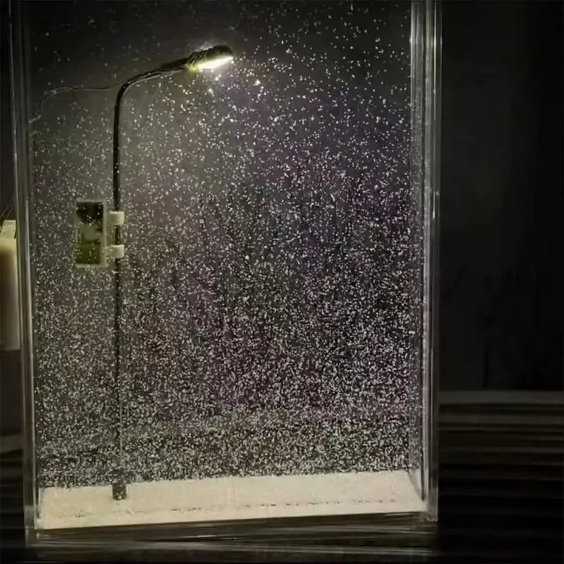 Snowfall Nightlamp display case with a glittery interior, illuminated by a street lamp.