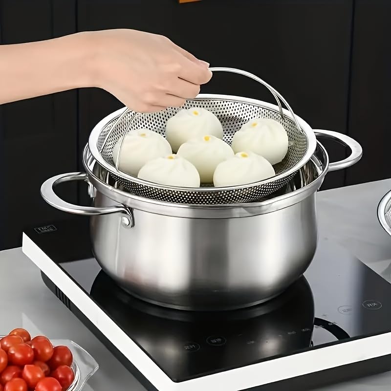 Stainless steel pot with steamer basket on a stove, containing white dumplings.