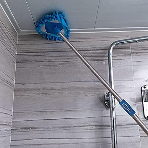 Cleaning mop with blue bristle head cleaning a shower door in a bathroom.