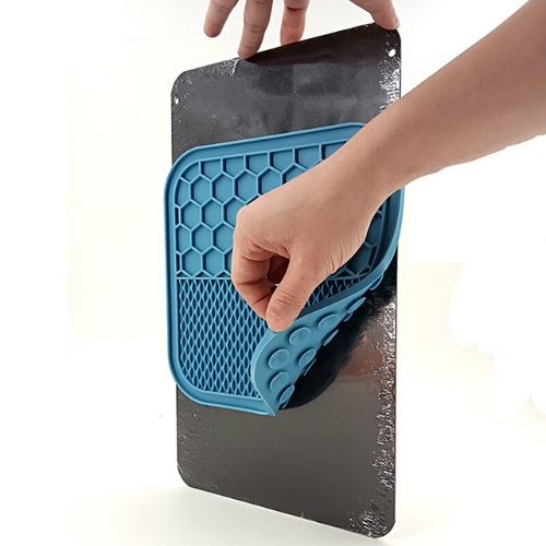 Person placing a blue silicone mat with honeycomb pattern onto a black surface Pet anxiety relief feeding mat


