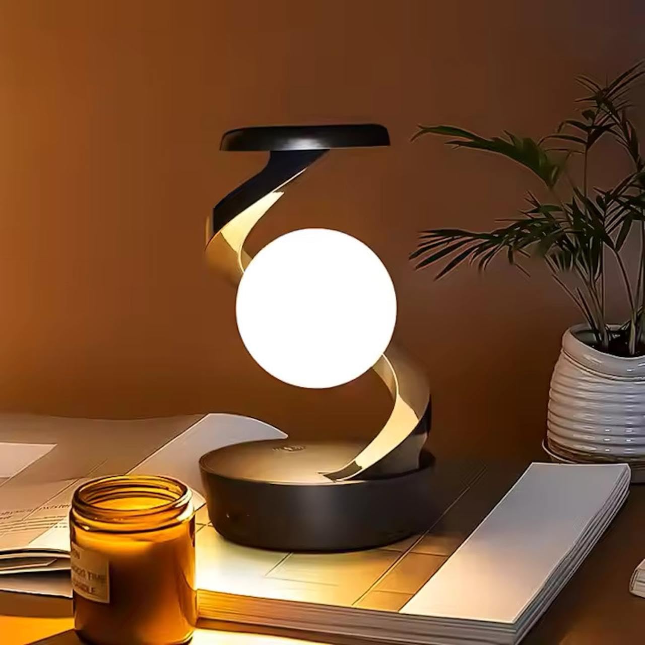 Modern table lamp on a desk with a candle and notebook in a warm setting