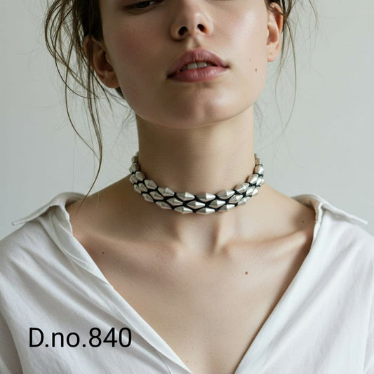 Person wearing a braided necklace with a plain background