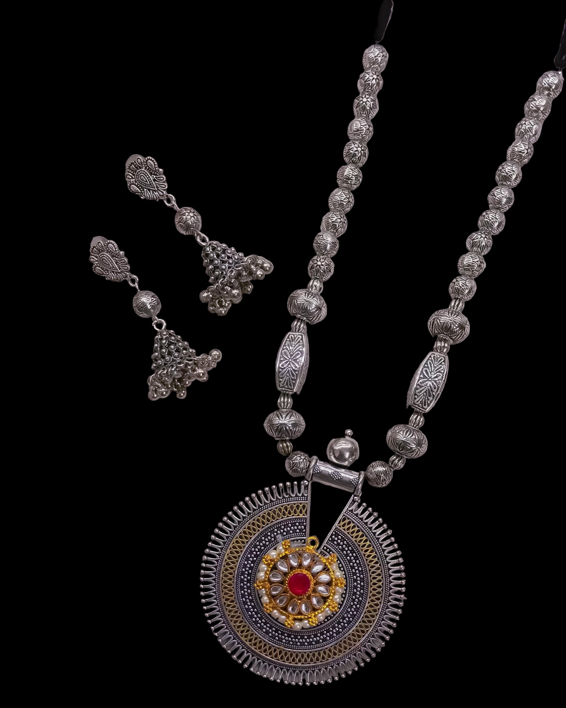 German silver long necklace with decorative pendant on a textured surface
